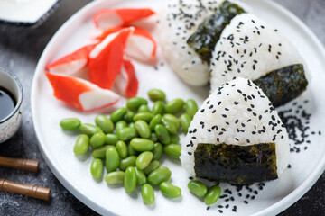 Wall Mural - Onigiri or rice formed into triangular shapes and wrapped with nori, close-up, selective focus