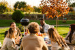 © Drobot Dean - Multiracial friends talking and laughing during barbeque in garden