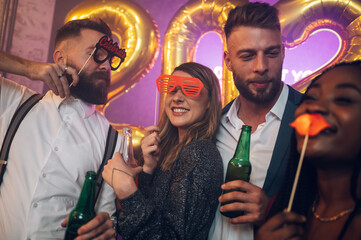 Happy group of friends celebrate New Year's Eve while dancing in the club