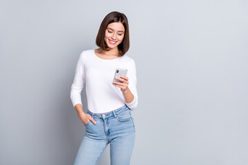 Photo of sweet bob hairstyle millennial lady look telephone wear shirt jeans isolated on grey color background