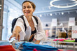 Overjoyed shopaholic woman grabbing clothes at seasonal discount black friday sale