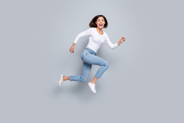 Canvas Print - Photo of sweet cute young woman wear white outfit jumping high running fast smiling isolated grey color background