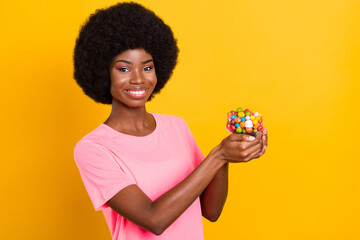 Poster - Photo of young cheerful afro girl happy positive smile hold candy dessert tasty diet isolated over yellow color background