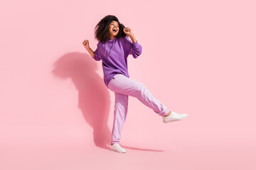 Photo of pretty shiny african lady dressed purple hoodie smiling dancing singing microphone isolated pink color background