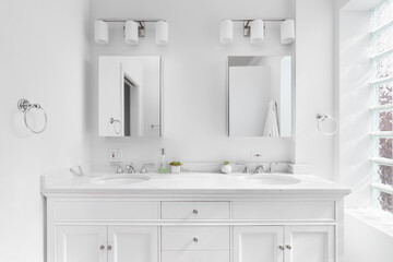 Wall Mural - A bright, white bathroom with a marble countertop, chrome hardware and faucets, and block window.