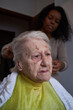 © oigro - caregiver, cutting her elderly woman hair