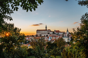 Wall Mural - View of Mikulov with beautiful Baroque castle on the rock at sunset,south Moravia,Czech Republic.Dominant of town skyline.Czech Chateau in Palava wine region.Picturesque town among vineyards.