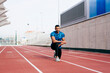 © ADDICTIVE STOCK - Athletic man stretching on the running track
