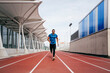 © ADDICTIVE STOCK - Fit man with sportswear and sunglasses running on the field track