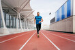 © ADDICTIVE STOCK - Fit man with sportswear and sunglasses running on the field track