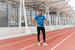 © ADDICTIVE STOCK - Athletic man standing on the running track