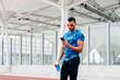 © ADDICTIVE STOCK - Athletic man using the phone on the running track