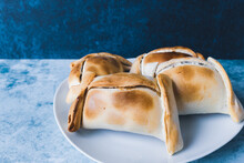 Chilean Empanadas, Made With Meat And Onion. Blue Background.