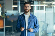© Liubomir - Happy bearded businessman entrepreneur startup owner standing in modern office looking at camera, smiling young hipster, creative man posing in workspace, business portrait