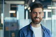 © Liubomir - Successful businessman with beard smiling and looking at camera happy, close up photo, in modern office