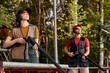 © Roman - Side View On Male And Female In Outdoor Range, Looking At Side At Target, After Shooting, Concentrated on Training, At Summer Season, Wearing Protective Equipment Uniform, Goggles And Headset