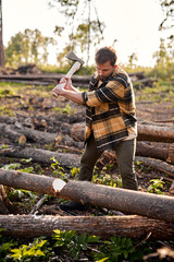 Sticker - Confident strong caucasian lumberjack work on sawmill and sawing big tree with ax. Bearded unshaven guy in plaid casual shirt engaged in wood working, lamberman engaged in forestry