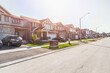 © alpegor - Newly built houses in a housing development on a sunny autumn day. Lens flare.
