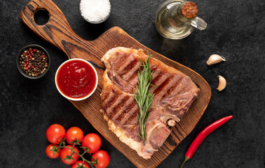 Wall Mural - grilled t-bone steak with spices on a stone background