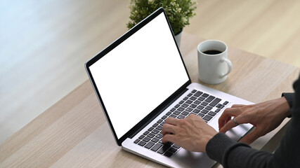 Close up view man sitting in living room and using laptop computer.