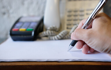 Wall Mural - Concept of an unrecognizable business person signing papers inside of the office during the day