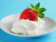 Strawberries with whipped cream on a blue background