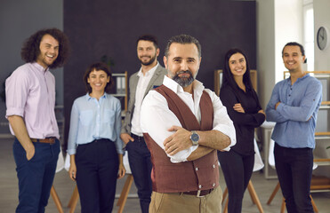 Wall Mural - Confident caucasian businessman standing with folded arms smiling at camera boardroom with diverse colleagues on background. Business team leader with executive company staff portrait