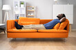 © Andrey Popov - African American Man Relaxing On Sofa