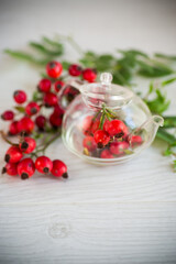 Wall Mural - ripe red rose hips on a wooden table