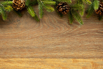 Wall Mural - Wood table with Christmas decoration including pine branches and pine cones. Merry Christmas and happy new year concept. Top view with copy space, flat lay.