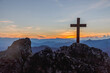 Silhouettes of crucifix symbol on top mountain with bright sunbeam on the colorful sky background