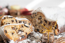 Traditional Christmas Stollen Made Of Dried Fruits And Nuts Sprinkled With Powdered Sugar On The Background Of A Christmas Decor With Candles. Traditional Christmas Cupcake