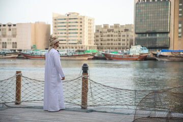 Wall Mural - Arab man overlooking deira canal in al seef district in Dubai