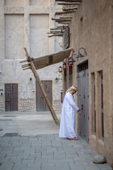 Wall Mural - Arab man opening his shop in the alleys of al seef district in Dubai