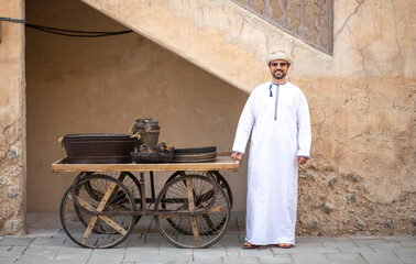 Wall Mural - Arab man standing in front of his merchandise in al Seef district in Dubai