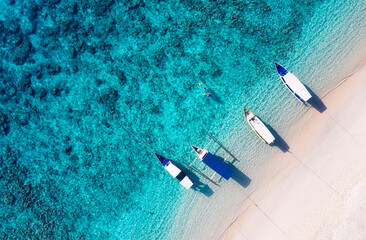 Wall Mural - Boat near the beach. Blue water background from top view. Summer seascape from air. Aerial landscape. Travel image