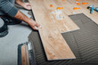 © hedgehog94 - Flooring and tiling. Professional tiler placing floor tiles on adhesive surface.