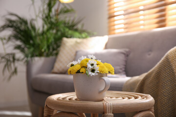 Canvas Print - Cup with beautiful bright flowers on table in living room