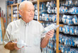 © JackF - Mature man visiting store of household goods in search of energy efficient light bulbs