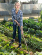 © JackF - Girl gardener using mattock at land with green seedlings in garden outdoor