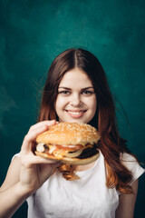 Wall Mural - cheerful woman eating hamburger snack close-up lifestyle