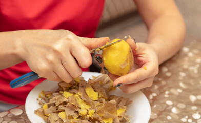 Sticker - A woman peels boiled potatoes with a knife.