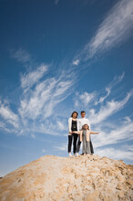 A Family Poses Standing On A Mountain Of Sand Against The Sky 3310.