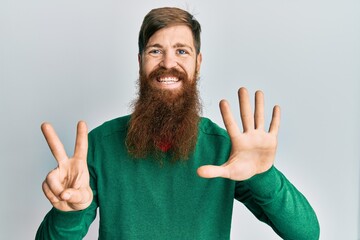 Redhead man with long beard wearing casual clothes showing and pointing up with fingers number seven while smiling confident and happy.