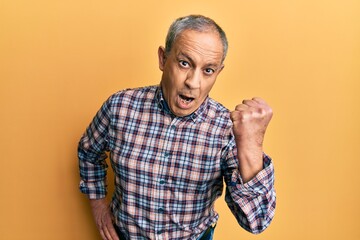 Sticker - Handsome senior man with grey hair wearing casual shirt angry and mad raising fist frustrated and furious while shouting with anger. rage and aggressive concept.