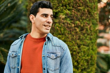 Young hispanic man smiling happy standing at the city.