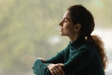 Music Of Rain. Side Shot Of Serene Latin Woman Relax By Window With Closed Eyes Listen Sound Of Raindrops Feel Pleasure. Calm Young Lady Enjoy Breathing Fresh Ozonized Air After Rainstorm. Copy Space.