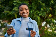 Young African American Woman Smiling Happy Holding Smartphone And Credit Card At The City