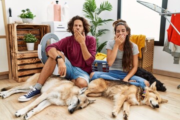 Sticker - Young hispanic couple doing laundry with dogs bored yawning tired covering mouth with hand. restless and sleepiness.