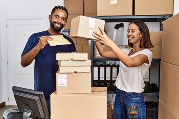 Wall Mural - Man and woman business partners smiling confident holding packages at storehouse